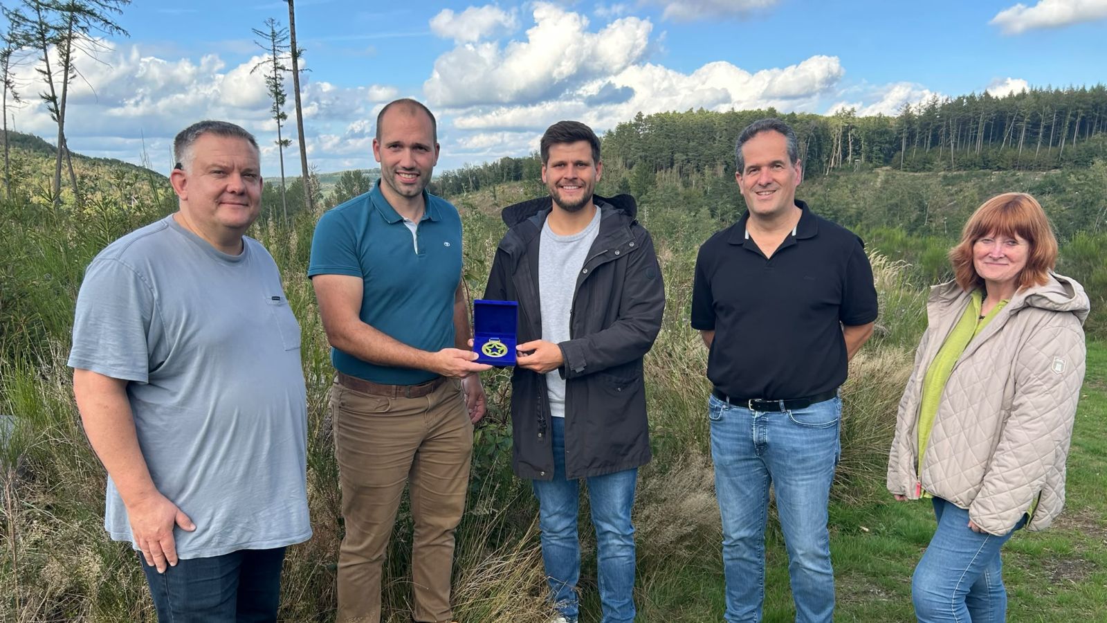 Auszeichnung für waldfreundliche Bejagung: Westenergie-Kommunalmanager Jonas Leyener (3. v. l.) überreicht Christopher Förster (2. v. l.) den Lokalstars-Award für die Waldgenossenschaft Burba
